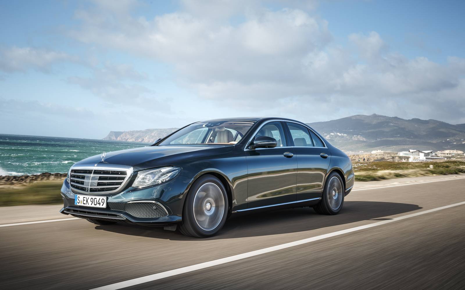 Luxury Mercedes-Benz sedan on a scenic coastal highway